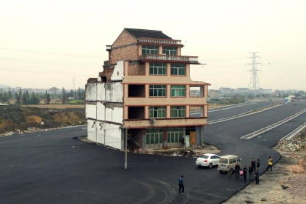 Luo Baogen, 67, and his wife, 65 own the house  in the middle of a huge dual carriageway in Wenling. Photo: AFP