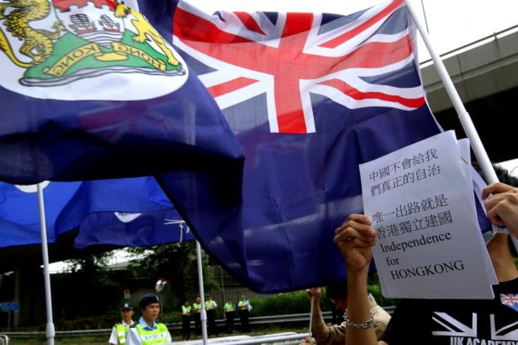 Members of "We are Hongkongers, Not Chinese" group wave a colonial-era Hong Kong flag in front of the Central Government's Liason Office in Hong Kong on October 1, 2012. Photo: SCMP