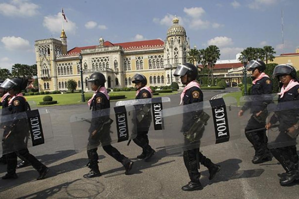 Thai policemen patrol inside the compound of Government House in Bangkok on Friday. Photo: AP
