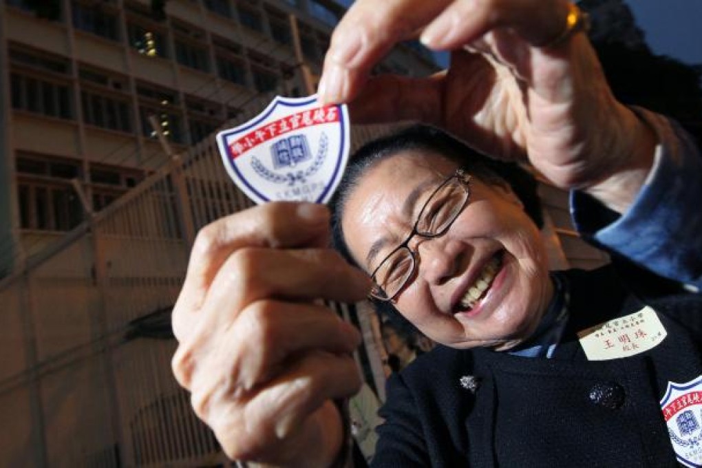 Former principal Wong Ming-chu holds up the old school badge as she revisits the now-empty Shek Kip Mei building. Photo: May Tse