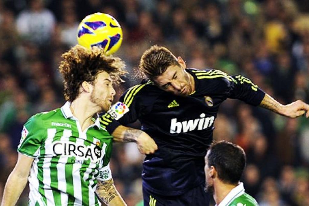 Betis' midfielder Jose Canas (left) vies with Real Madrid's defender Sergio Ramos on Saturday. Photo: AFP