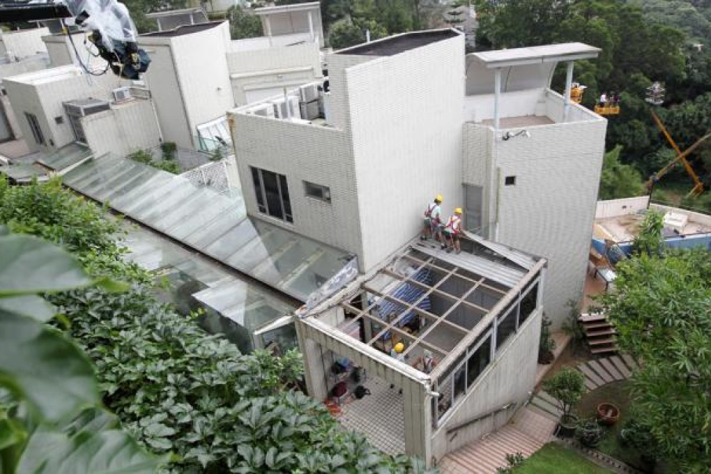 Construction workers remove one of the illegal structures at the home of Chief Executive-elect Leung Chun-ying. Photo: Dickson Lee