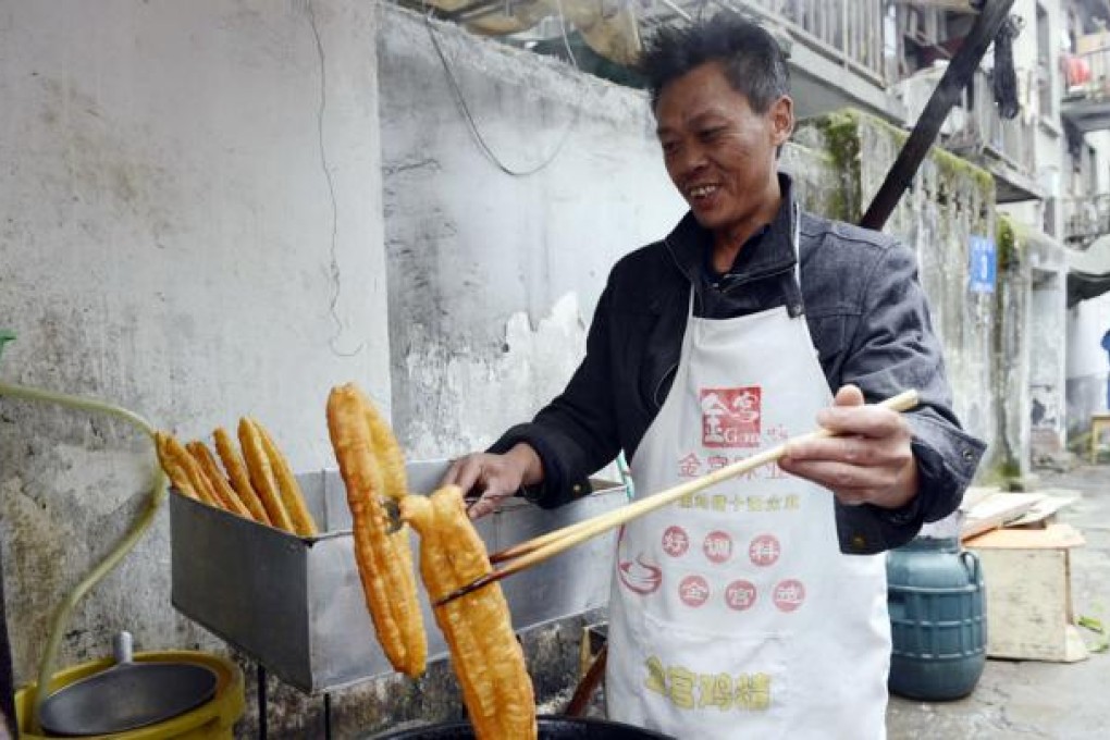 Li Gang fries dough sticks in Chengdu, after improving their recipe. Photo: Chengdu Business Daily