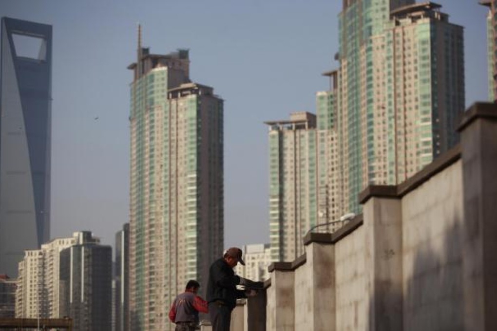 Workers build walls in Shanghai's Lujiazui financial area. Some predict major economic reform under Xi Jinping's leadership. Photo: Reuters