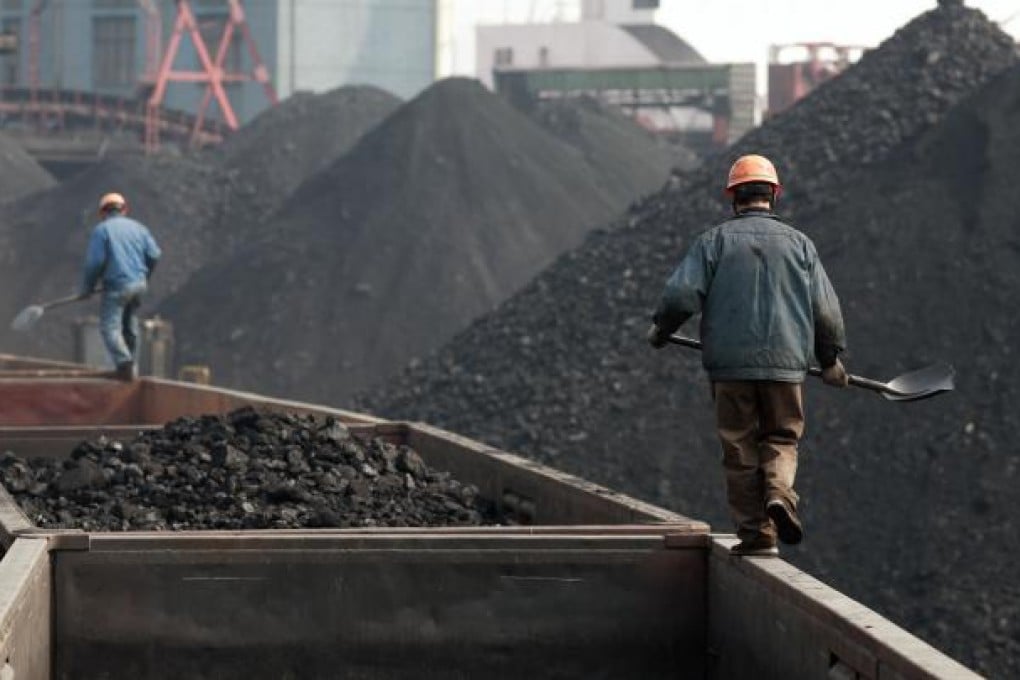 Workers stand on a train to monitor the loading of coal at a coal depot in Shanghai on February 21, 2008. Photo: Bloomberg