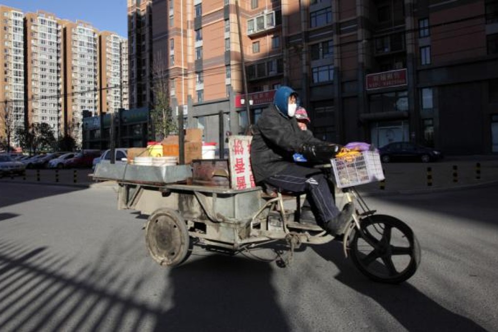 A street vendor rides a motor trike past residential buildings on the outskirts of Beijing. While economic growth rates in the richer provinces may well tail off over the coming years, the country's poorer regions can still grow rapidly while catching up. Photo: Bloomberg