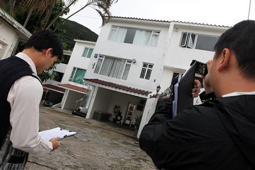 Building department staff inspect housing secretary Duncan Pescod's property in Clearwater Bay for illegal structures on Monday. Photo: Felix Wong
