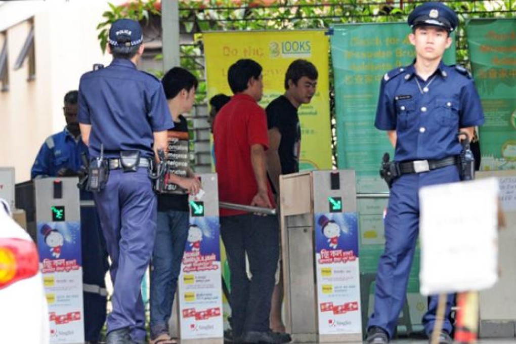 Policemen stand by the entrance to a foreign workers dormitory in Singapore on Monday. Photo: AFP