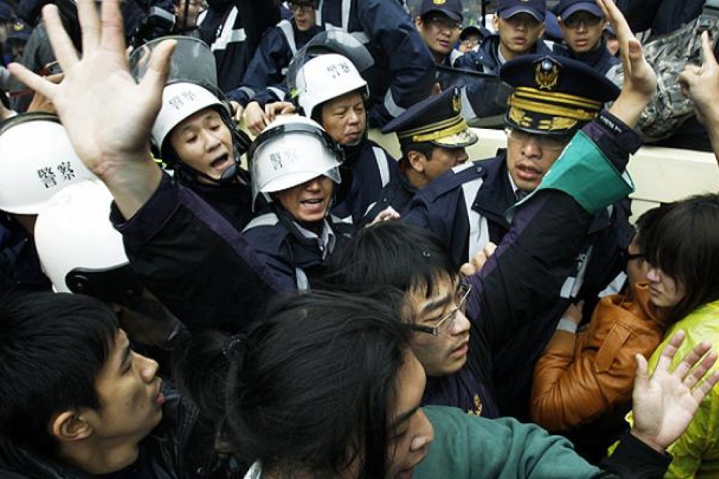 Demonstrators scuffle with police during a protest against the sale of influential media outlets to a pro-China businessman in Taipei on Tuesday. Photo: AP