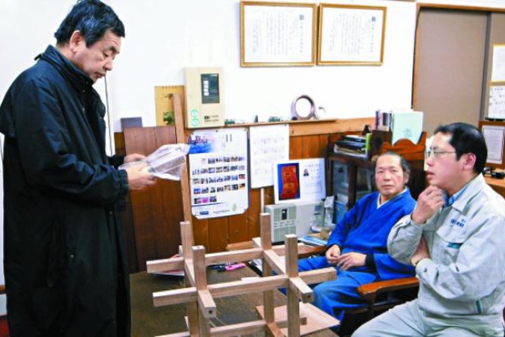 Kengo Kuma (left) discusses the chidori process with associates.