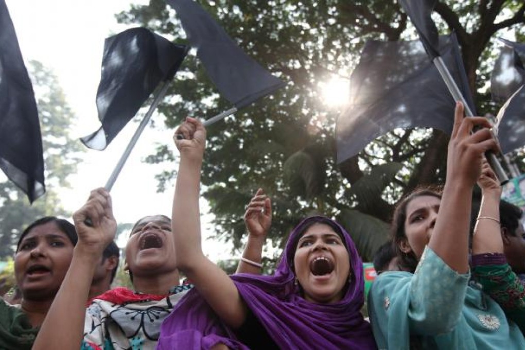 Garment workers shout slogans as they attend a mourning procession for the death of the workers of the Ashlia fire accident in Dhaka, Bangladesh on 27 November 2012. Photo: EPA