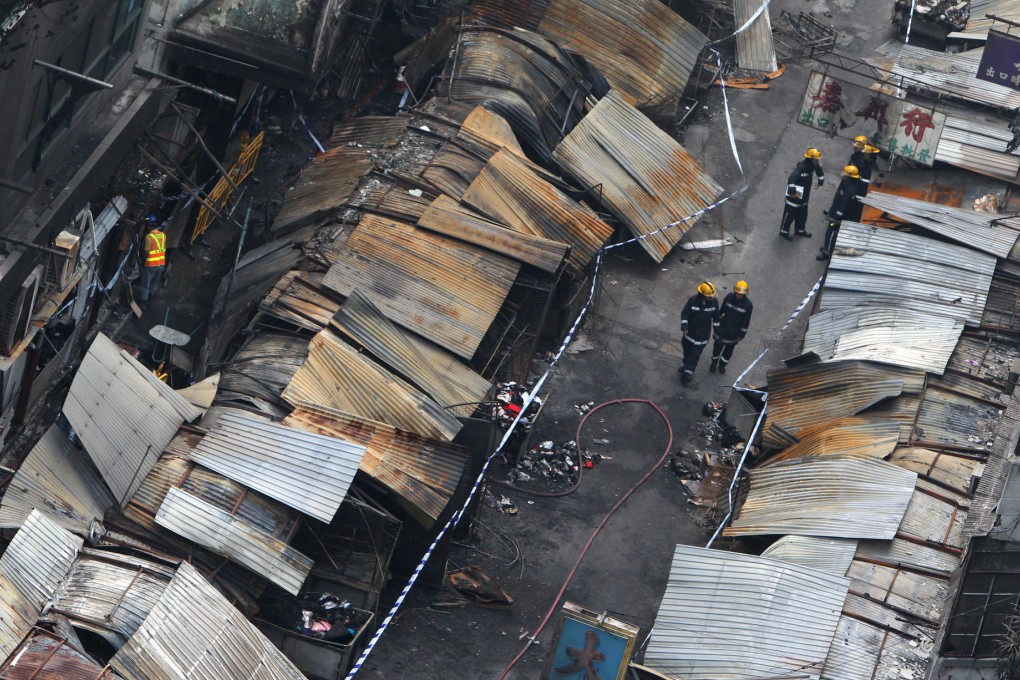 Police and firemen survey the fire scene. Photo: Felix Wong
