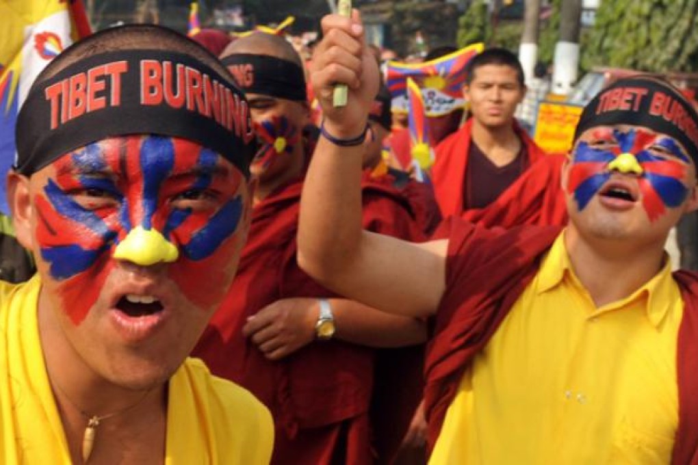 Tibetan Buddhist monks and members of the Tibetan Youth congress hold placards and flags while shouting slogans during a protest in Siliguri on Wednesday. Photo: AFP