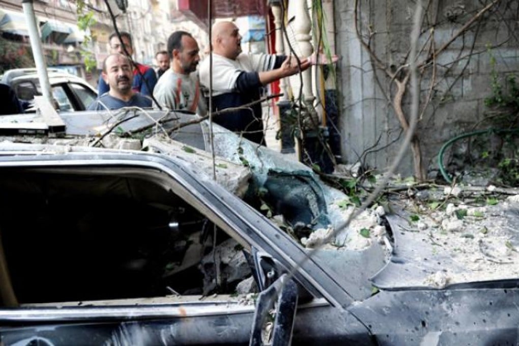 Syrians inspect the scene of a car bomb attack in the Jaramana suburb of Damascus. Photo: EPA