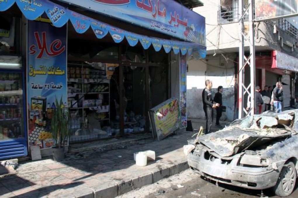 A damaged car is seen at the area where two booby-trapped cars exploded in Jaramana area, Damascus, Syria. Photo: EPA