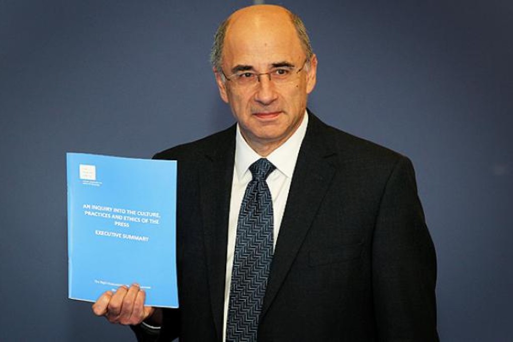 Lord Justice Brian Leveson  poses for photographers as he delivers his report 'Inquiry into the Culture, Practices and Ethics of the Press' in London on Thursday. Photo: AP