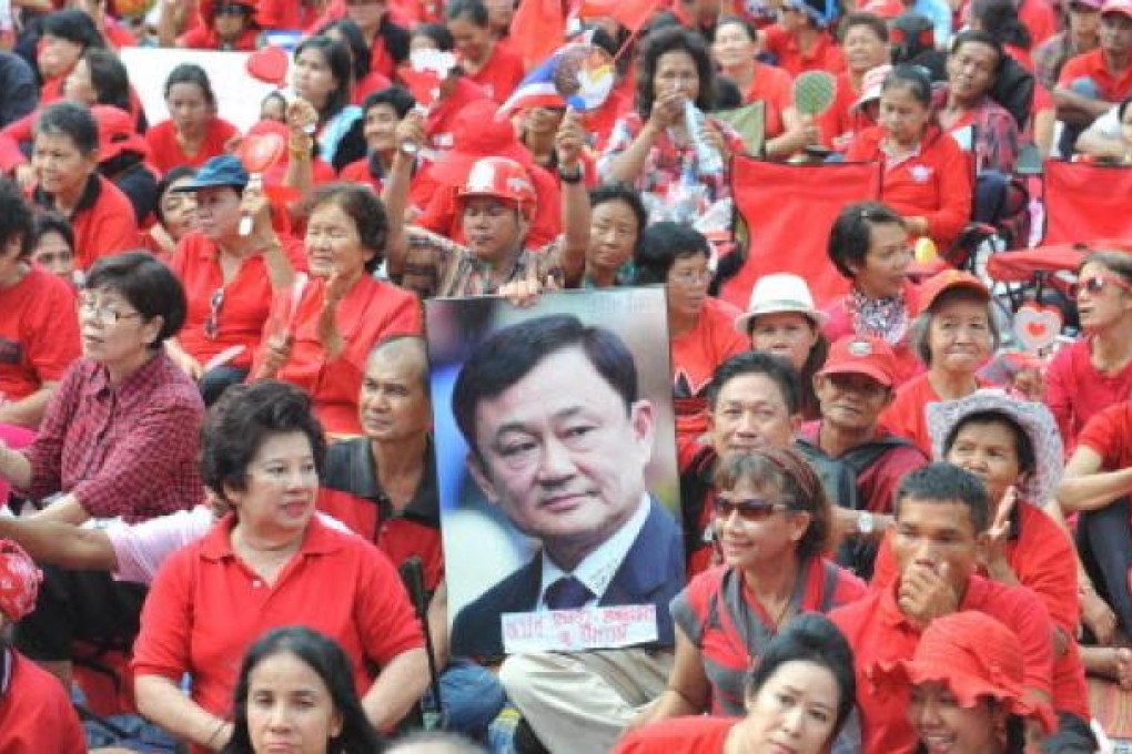 "Red shirt" supporters hold a picture of former premier Thaksin Shinawatra during a rally in Bangkok. Photo: Xinhua