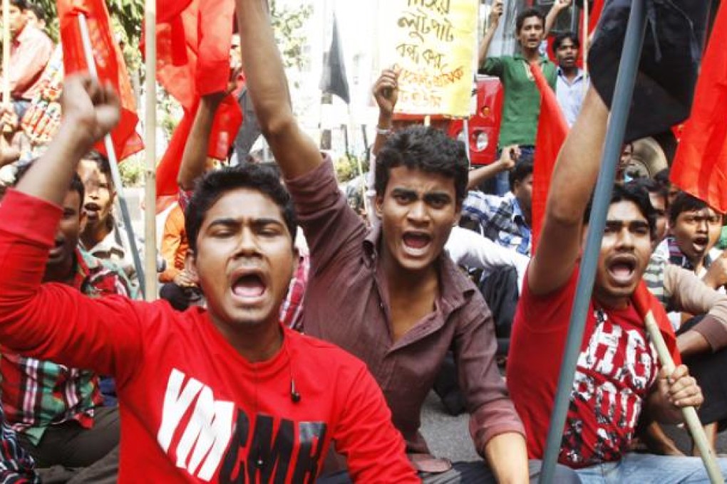 Bangladeshi garment workers shout slogans as they participate in a protest to mourn the death of the victims of a fire in a garment factory in Dhaka on Friday. Photo: AP