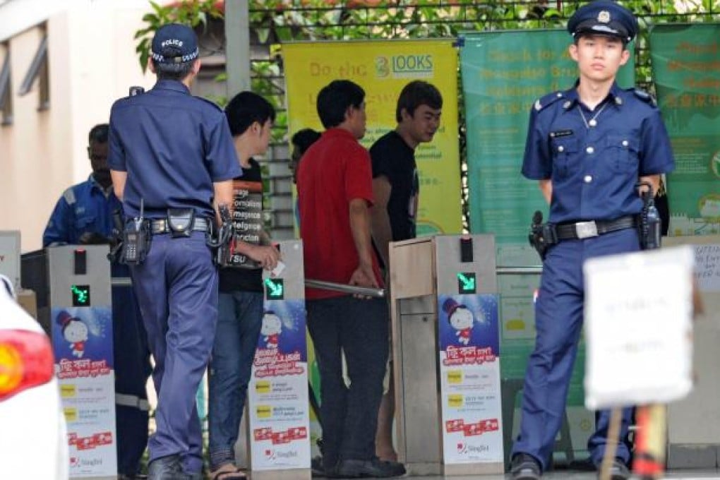 Policemen stand by the entrance to a foreign workers dormitory in Singapore. Photo: AFP
