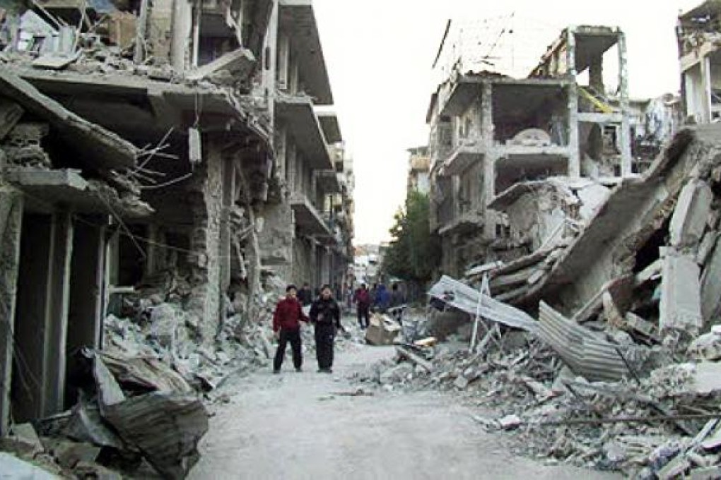Syrian citizens walk through in a destroyed street as fighting continues to rage. On Thursday, Syrian troops mounted an assault on rebels near Damascus. Photo: AP