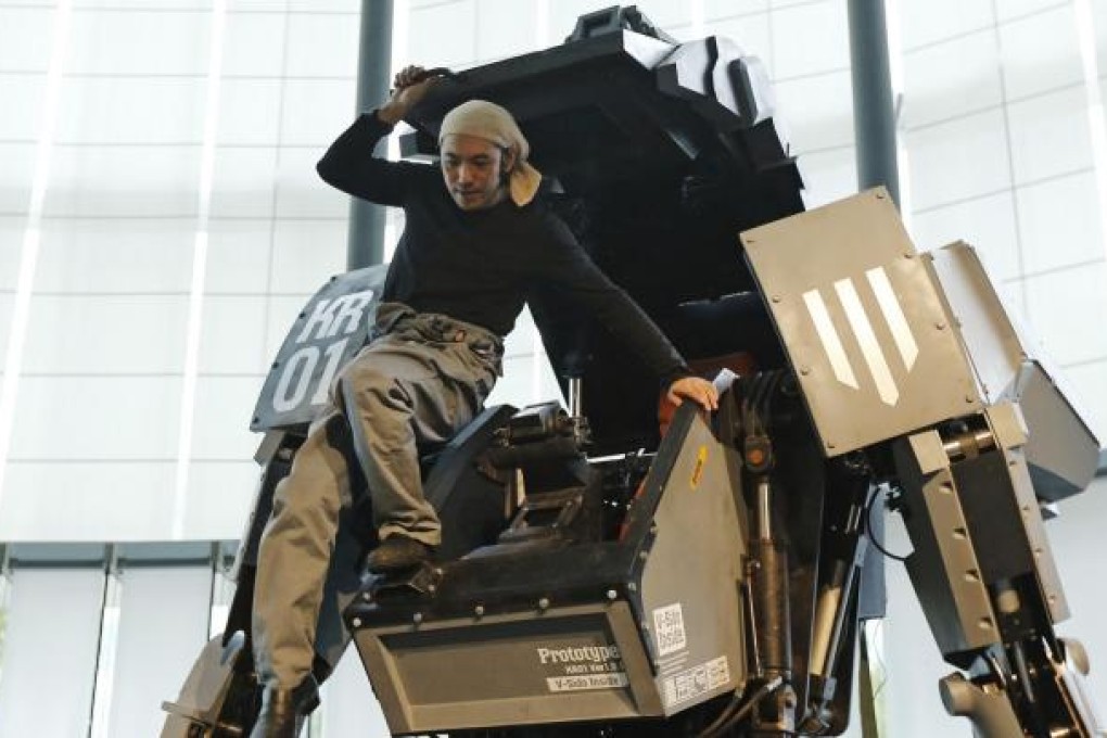 Japanese artist Kogoro Kurata climbs out of his robot. Photo: Reuters