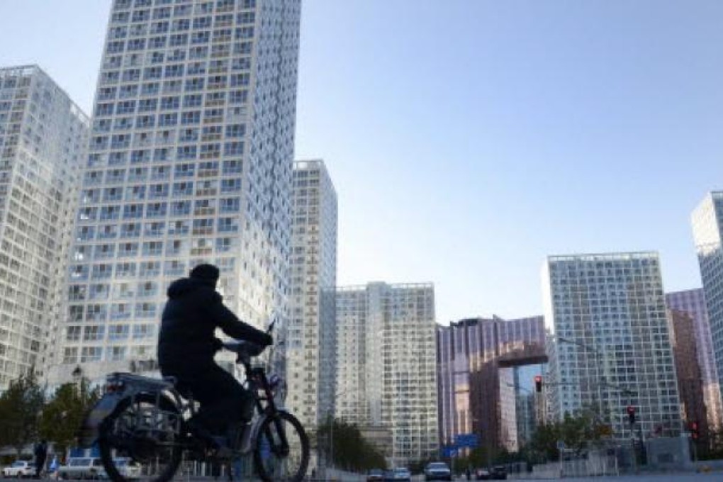 A man rides an electric bike along a street in the central business district in Beijing on November 30, 2012. Photo: AFP