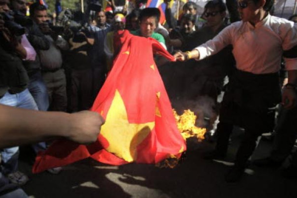 Exiled Tibetans burn a Chinese flag during a protest rally to express solidarity with Tibetan self-immolators and to appeal for immediate international intervention in New Delhi, India, Wednesday, Nov. 28, 2012. Photo: AP