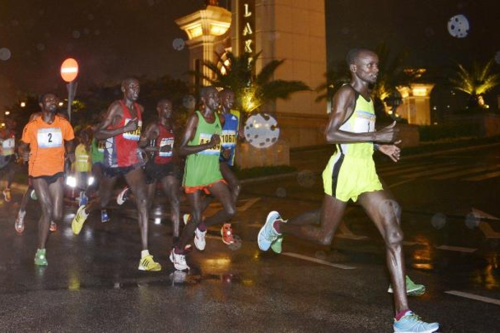 The leading pack races through heavy rain in Macau. The eventual winner, Haile Gemeda, is in the orange shirt. Photo: Richard Castka