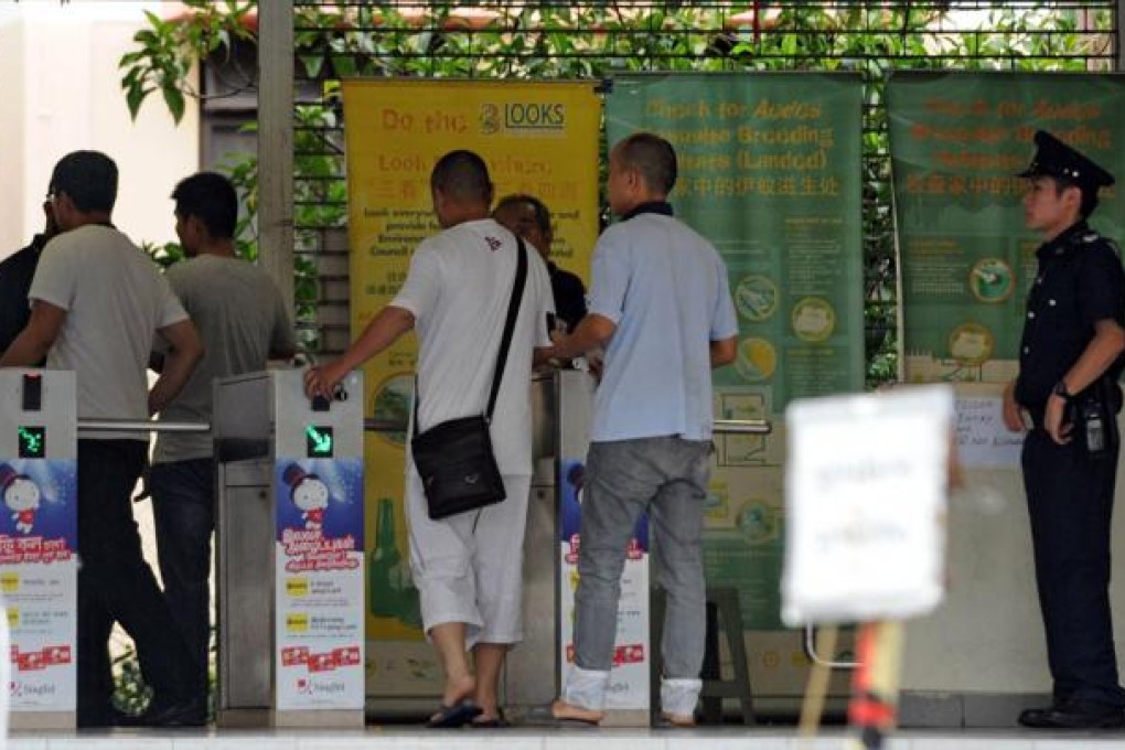 A policeman looks on as foreign workers enter their dormitory in Singapore on November 26, 2012. Photo: AFP