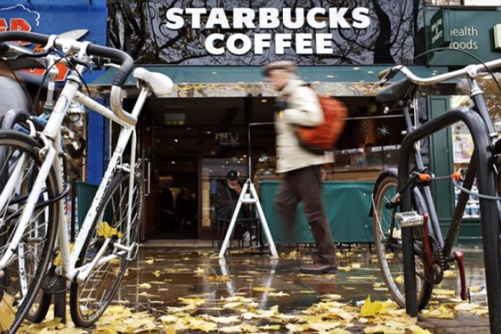 A man walks past a branch of the American coffee chain Starbucks in London. Executive officers of multinational companies Starbucks, Google and Amazon are facing allegations related to tax payments in the United Kingdom. Photo: EPA