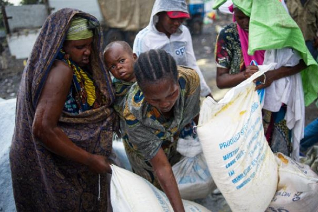 A group of internally displaced Congolese collect food aid in the rain at the Mugunga III IDP camp in the east of the Democratic Republic of the Congo on Sunday. Photo: AFP
