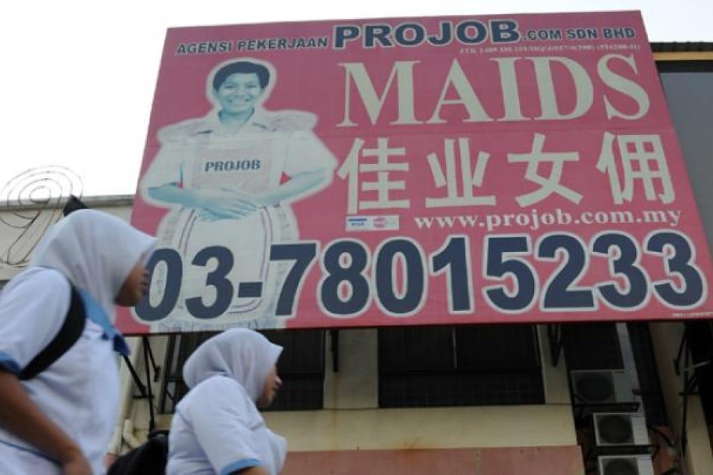 Women walk in front of a maid agency office in Kuala Lumpur. Photo: AFP