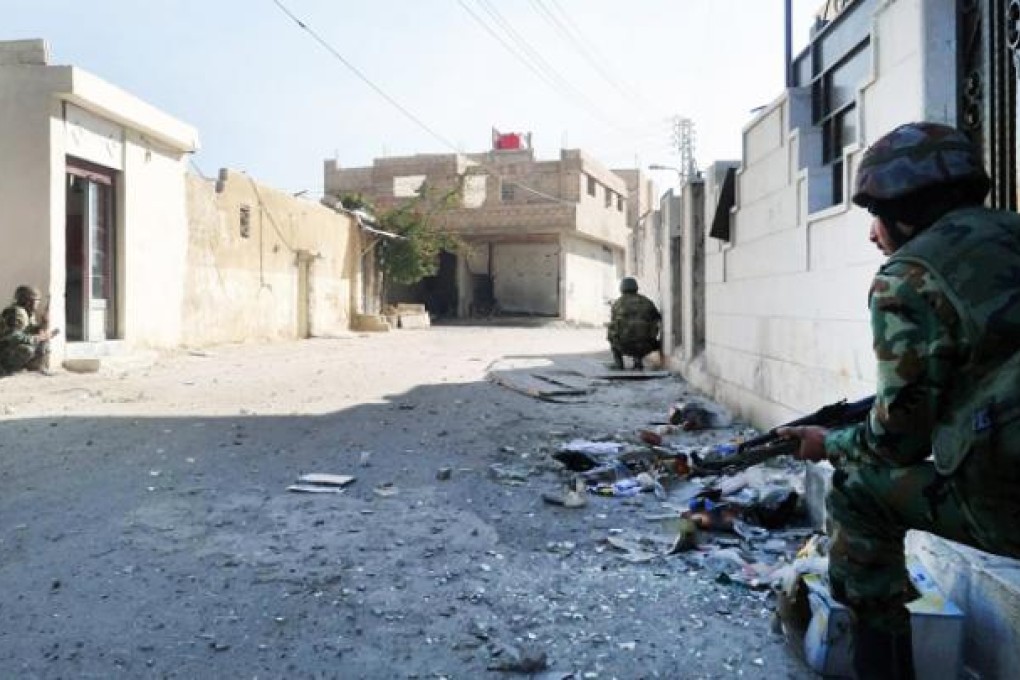 Syrian army soldiers take up their positions during a patrol in Darayah area, southern rural Damascus, on Sunday. Photo: EPA