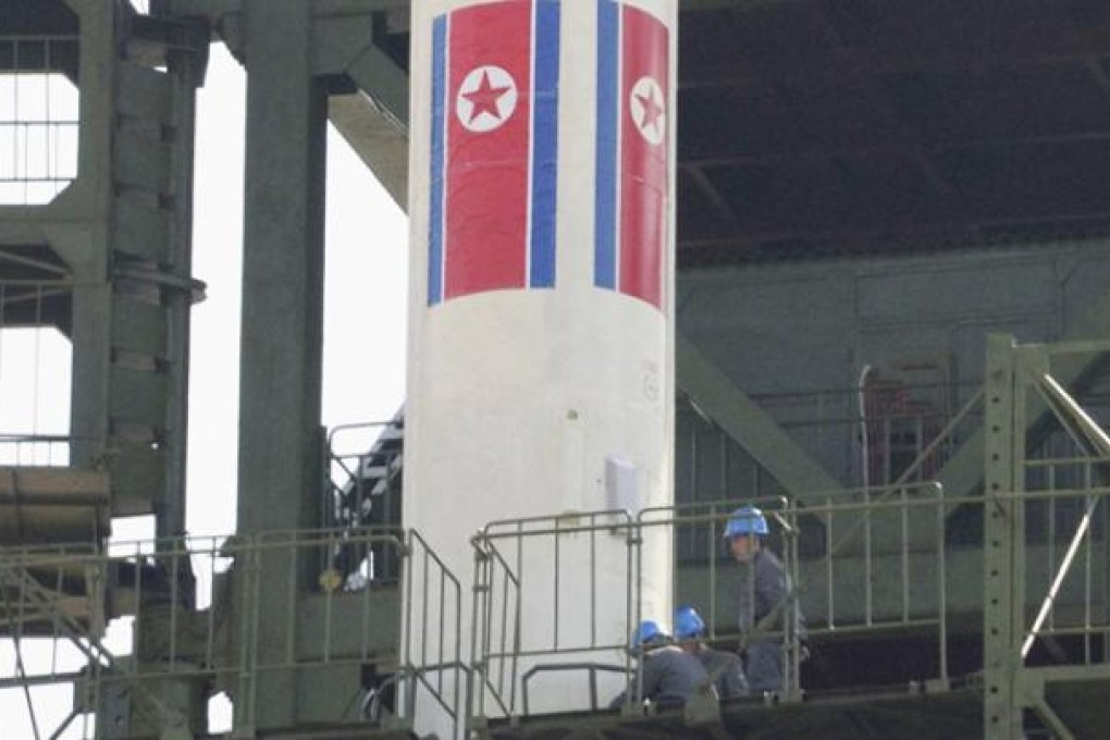 Engineers check the top of a rocket sitting on a launch pad at the West Sea Satellite Launch Site, northwest of Pyongyang, in April. Photo: Reuters