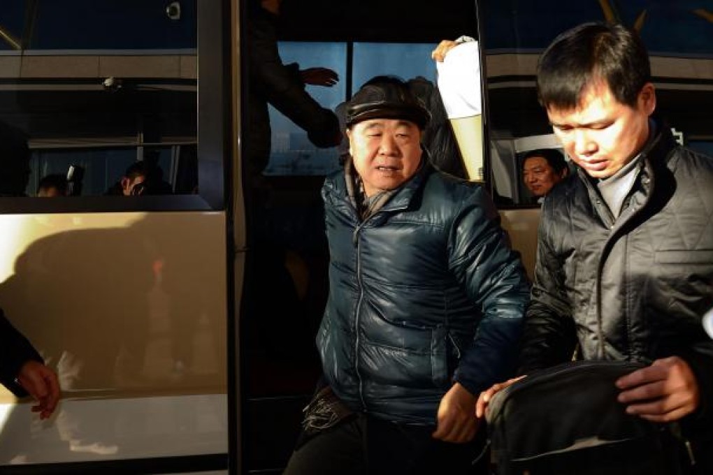 Mo Yan (left) arrives at the Beijing Capital International Airport on his way to Sweden to accept the Nobel literature prize. Photo: Xinhua