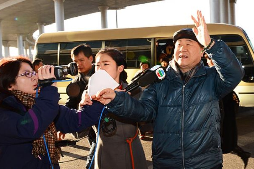 Nobel Prize for Literature winner, Mo Yan, talks to journalist outside Beijing airport before leaving for Sweden to accept the award. Photo: Xinhua