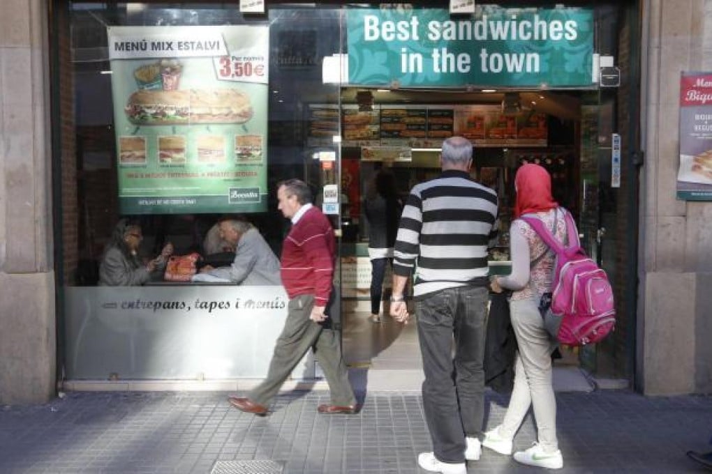 Tourists review a Catalan menu in Barcelona. Photo: Reuters