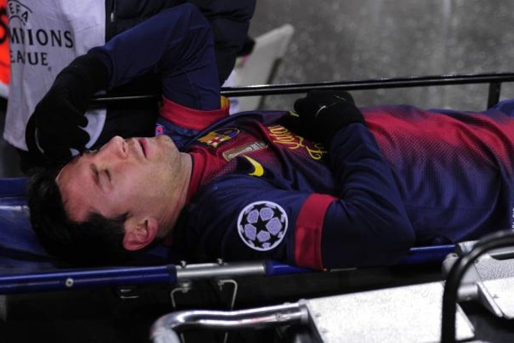 Barcelona forward Lionel Messi leaves the pitch on a stretcher after being injured during a Champions League match against SL Benfica. Photo: AFP