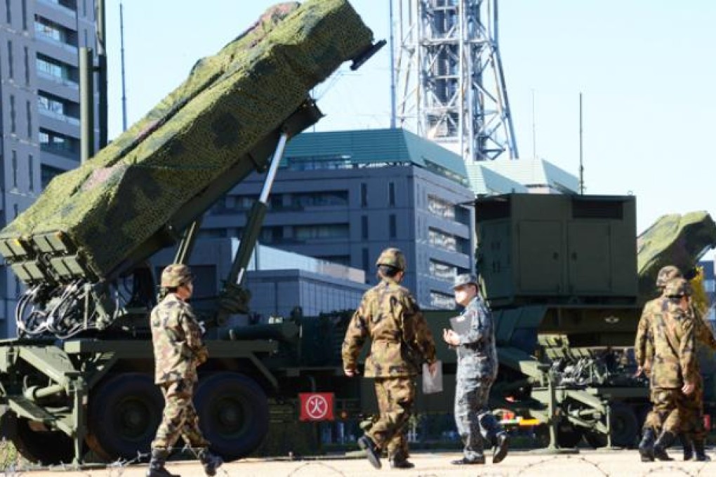 Officers of the Ground Self-Defence Force (SDF) walk in front of Japan's Patriot Advanced Capability-3 (PAC-3) missile launcher in Tokyo on Thursday. Photo: AFP