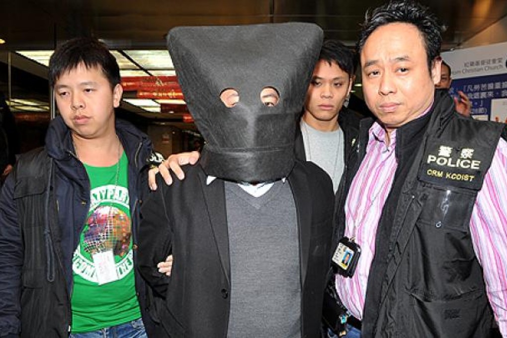 Police return with John Yan, centre in hood, to his company's premises in Hong Hom to search for evidence on Thursday. Photo: SCMP Picture