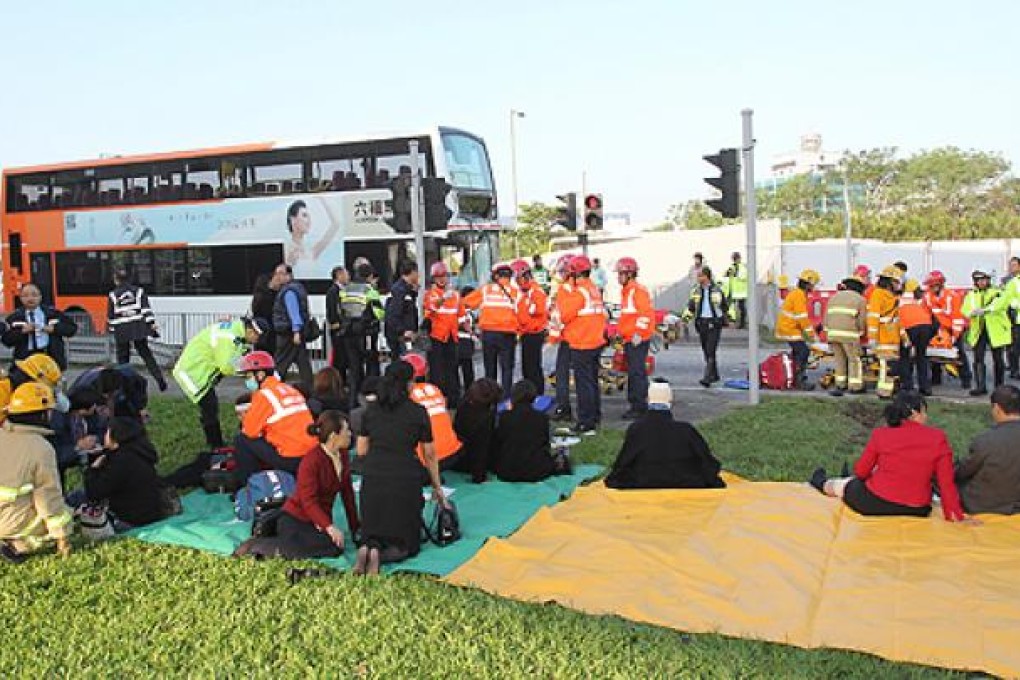 Rescue workers and firemen treat bus passengers and pedestrians after a bus collusion on Catering Road East on Thursday. Photo: SCMP Picture