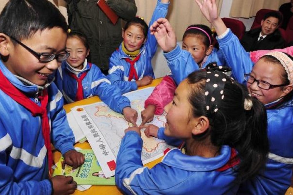 Students from a Lhasa primary school identify the different regions of China on a national map. Photo: Xinhua