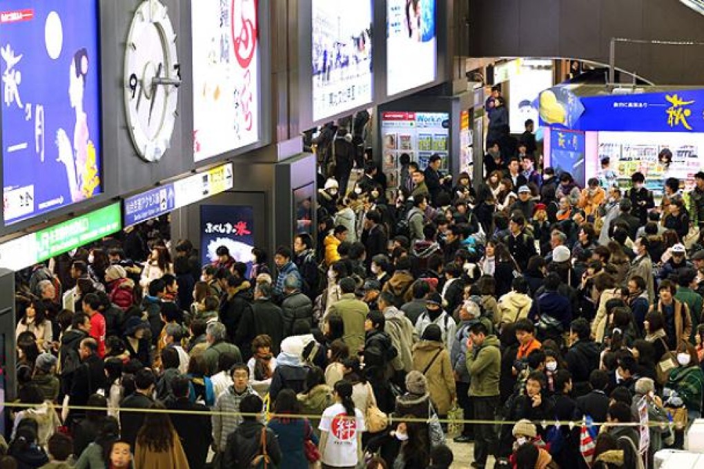 Passengers wait at Sendai railway station after trains were stopped when a powerful earthquake hit Miyagi prefecture, northeastern Japan, on Friday. Photo: AFP