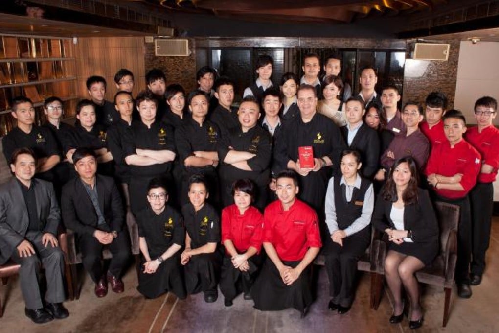 Harlan Goldstein (holding a Michelin guide) with his restaurant team.