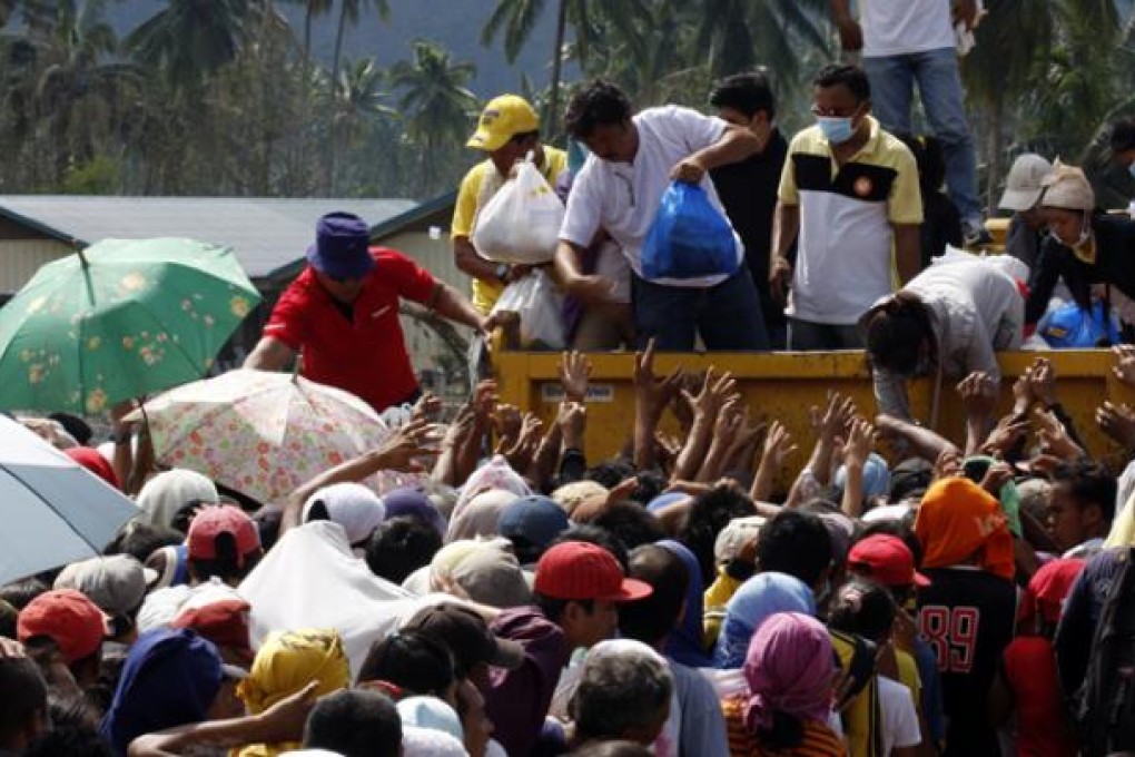 Typhoon-affected residents wait for relief food in a heavily damaged town of New Bataan of Compostela Valley Province, the Philippines, on Sunday. Photo: Xinhua