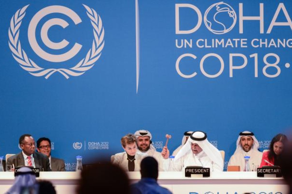 President of the conference, Abdullah bin Hamad al Attiyah (second from right, front) announces the final agreements of the UN Climate Change Conference. Photo: Xinhua