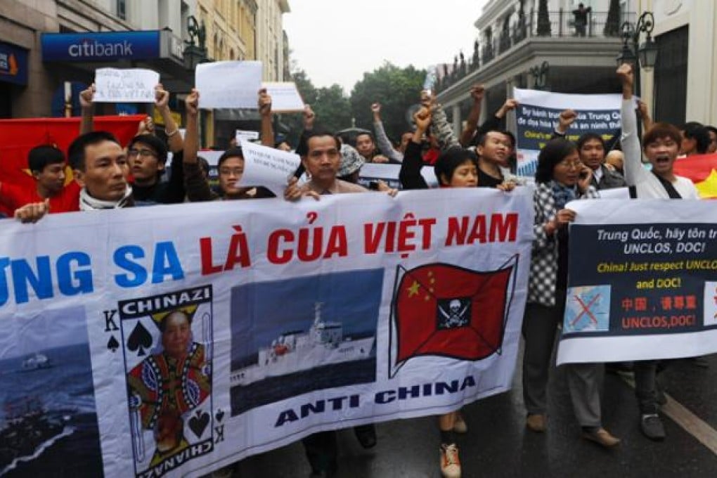 Protestors shout anti-China slogans and hold banners as they march towards the Chinese embassy in central Hanoi on Sunday. Photo: AFP