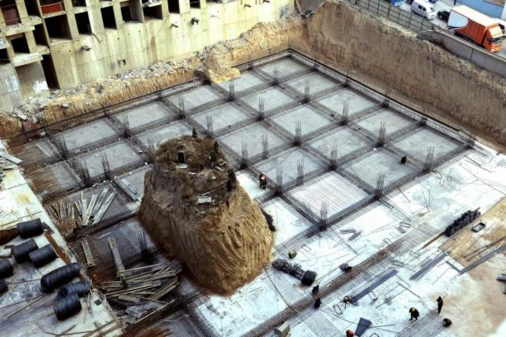 Chinese workers build around a grave mound 10 metres high, at a construction site in a village in Taiyuan, north China's Shanxi province. Photo: AFP