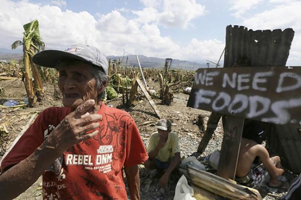 A resident at Montevista township begs for aid from passing motorists in Compostela Valley. Photo: AP