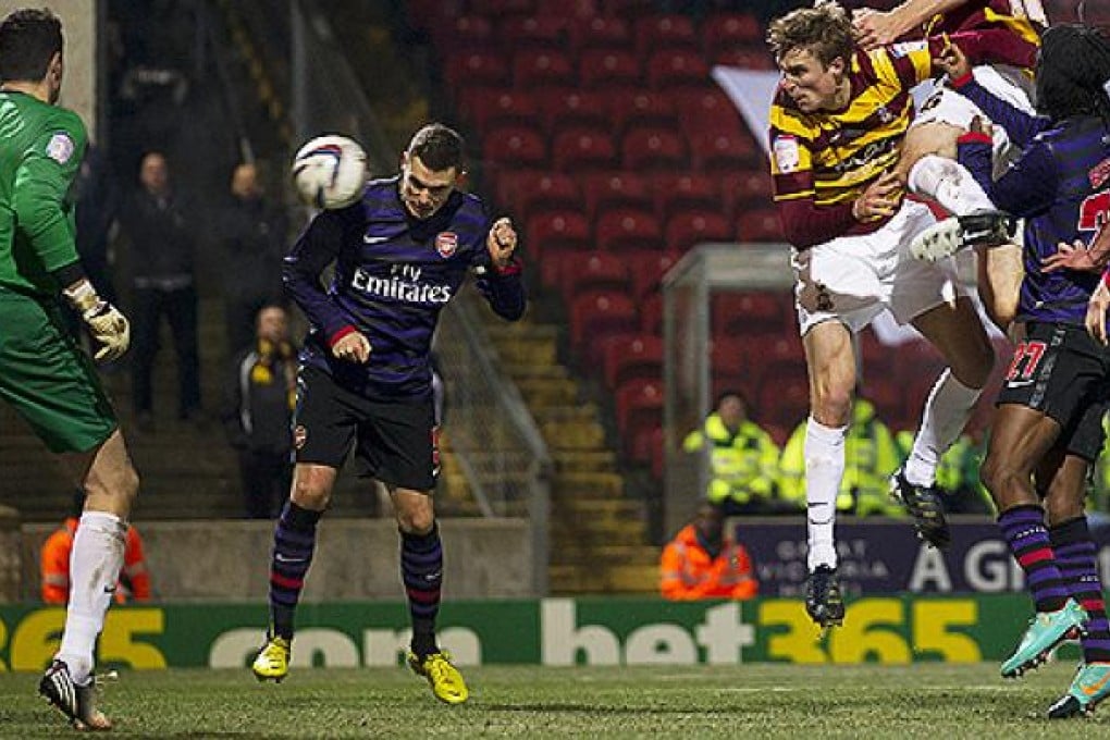 Arsenal's Thomas Vermaelen (centre left) scores past Bradford City's Matt Duke (left). Photo: AP
